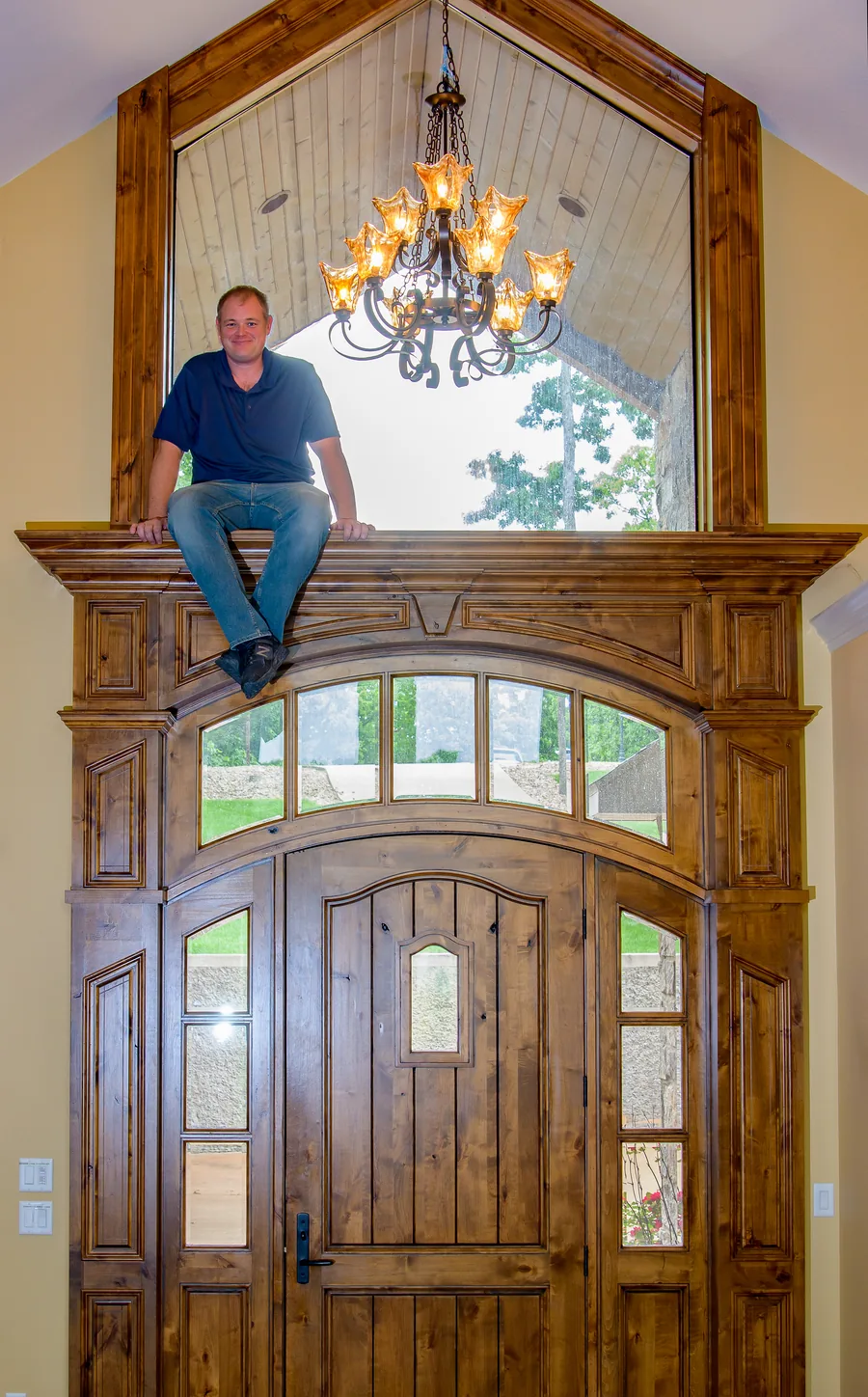 Cloke's owner seated on a custom arched wood entryway he built